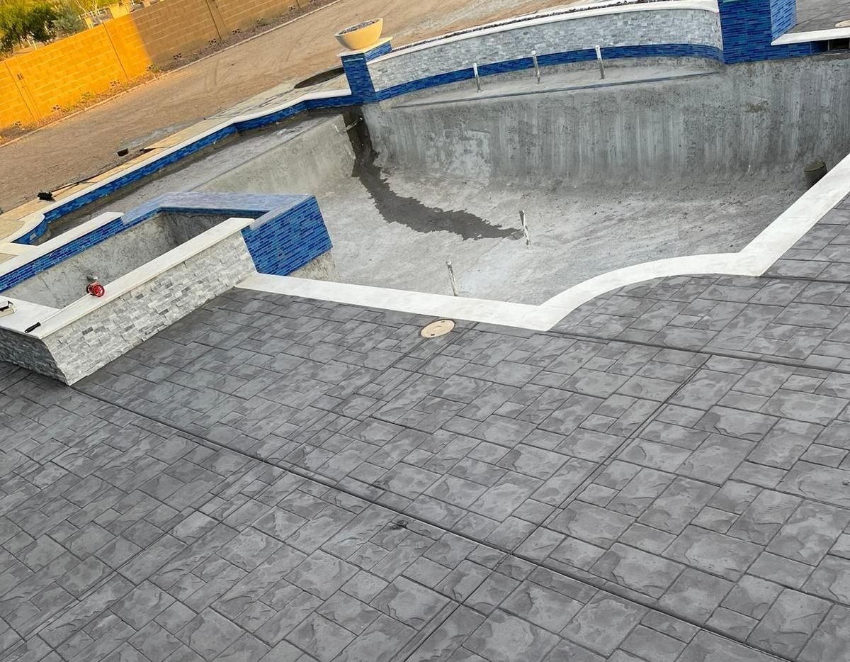 stamped concrete pool deck patterned in squares of different sizes